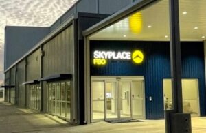 Exterior of the SkyPlace FBO terminal building at dusk with illuminated signage and a covered entrance
